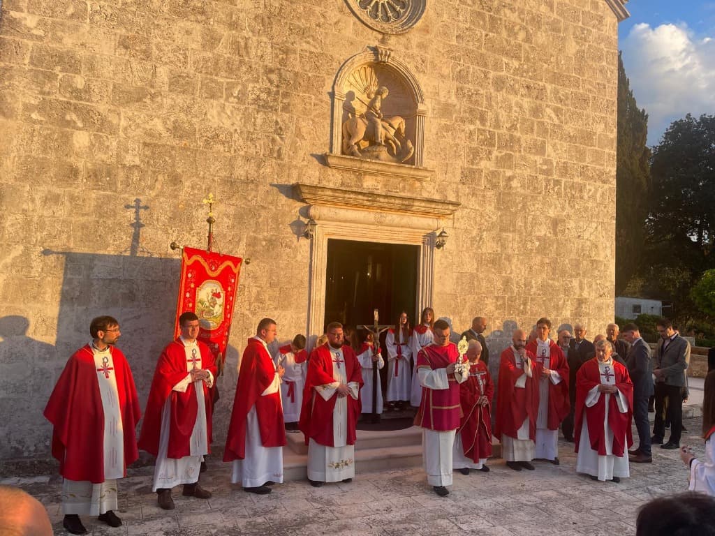Svećenici i vjernici u procesiji ispred župne crkve s barjakom sv. Jurja
