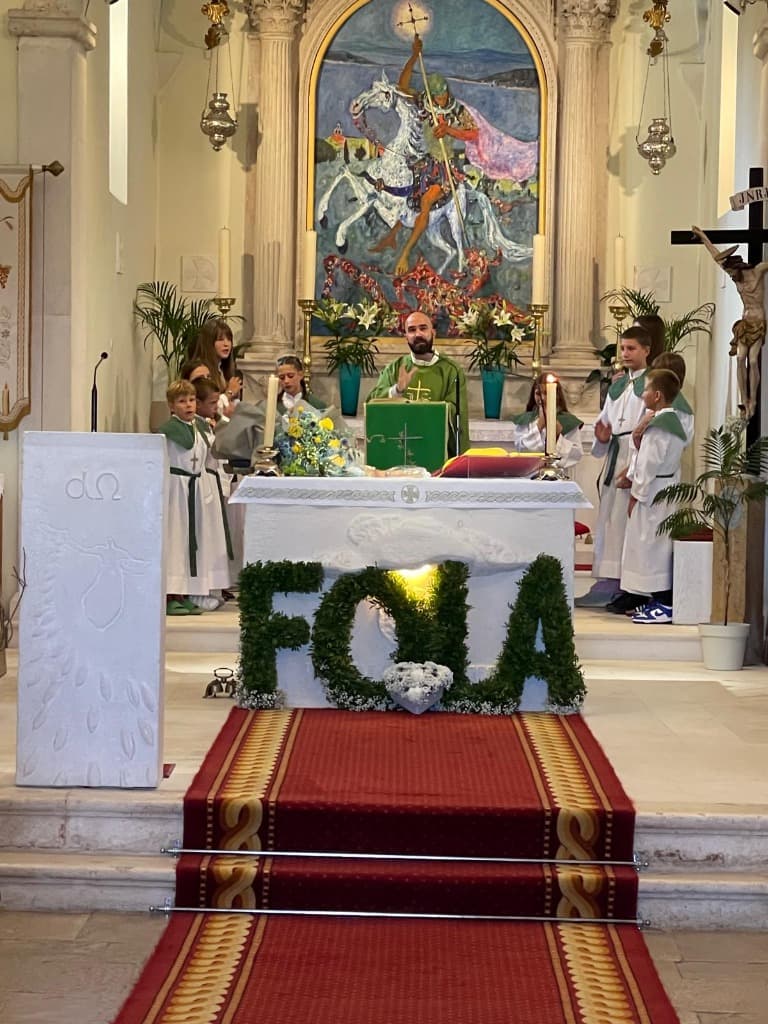 Župnik predmoli svetu misu za oltarom okružen djecom